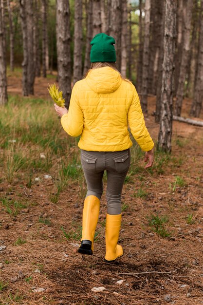 Back view woman taking a walk in the forest