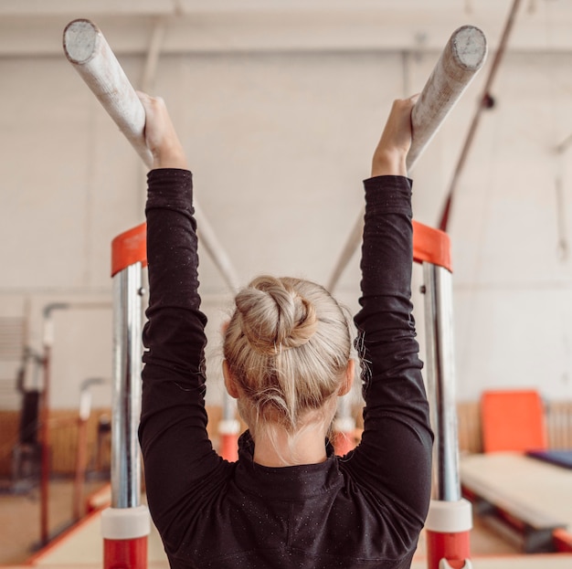 Free photo back view woman training for gymnastics championship