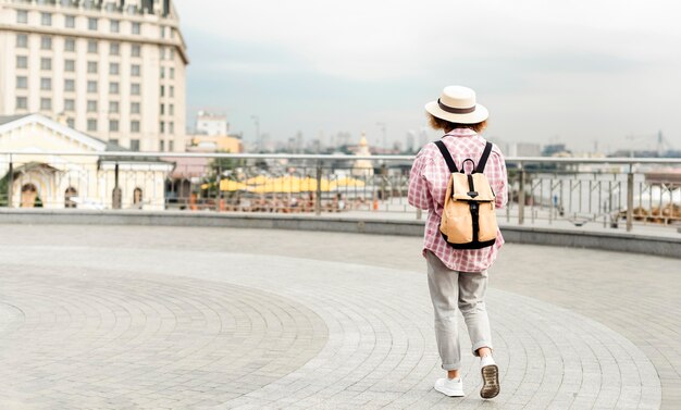 Back view woman traveling to a new place with copy space