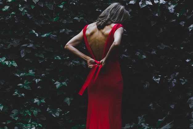 Free photo back view woman tying dress