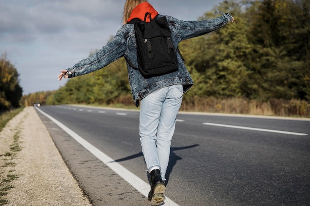 Vista posteriore della donna che cammina lungo la strada