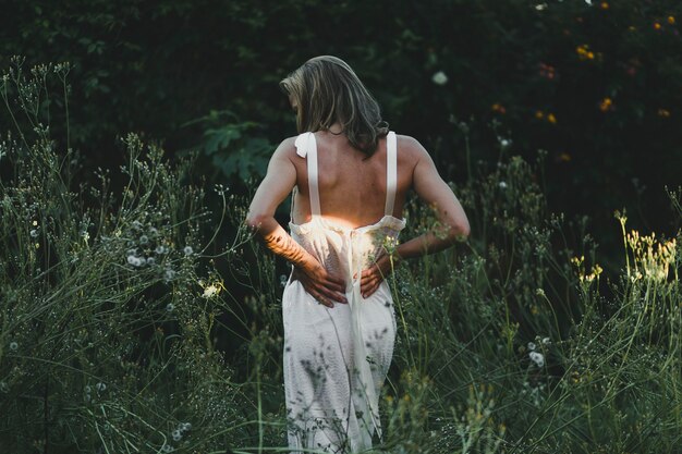 Back view woman walking in field