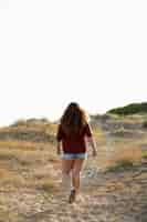 Free photo back view of woman walking outdoors in nature