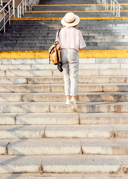 Free photo back view woman walking the stairs