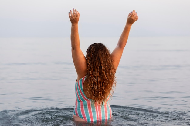 ビーチで水の中の女性の背面図