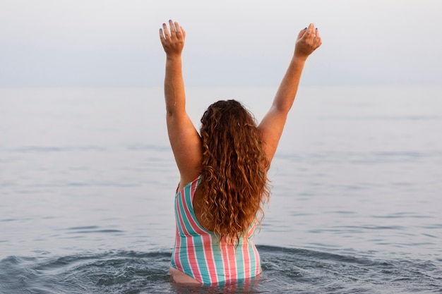 Back view of woman in the water at the beach