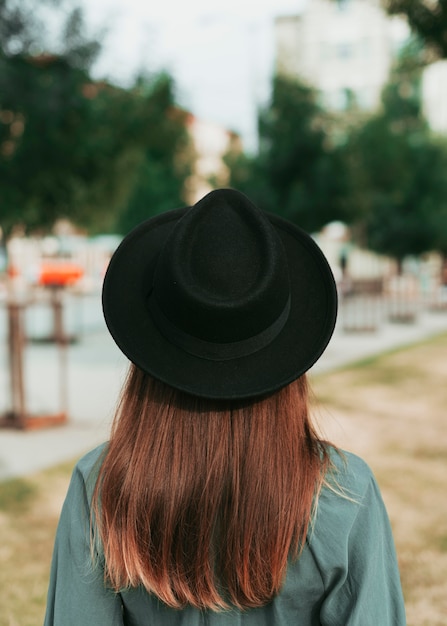 Back view woman wearing a black hat in autumn