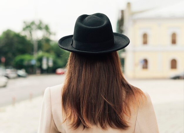 黒い帽子をかぶっている背面図女性