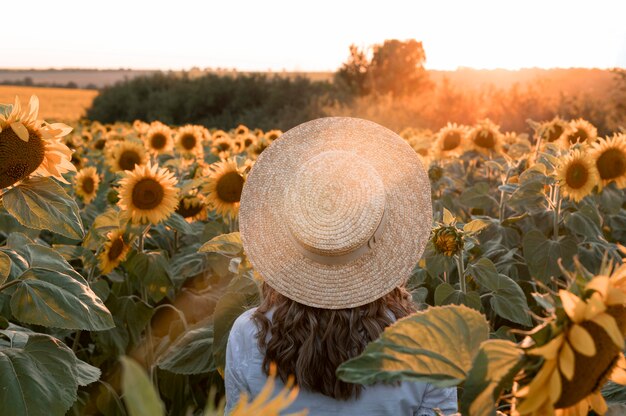 Вид сзади женщина в шляпе в поле