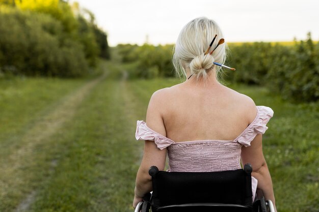 Back view of woman in wheelchair outdoors