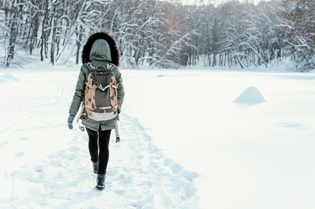 Back view woman with backpack on winter day