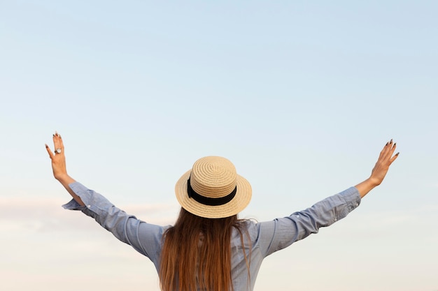 Back view of woman with posing outdoors with arms open