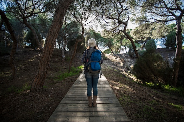 Back view woman on wooden path