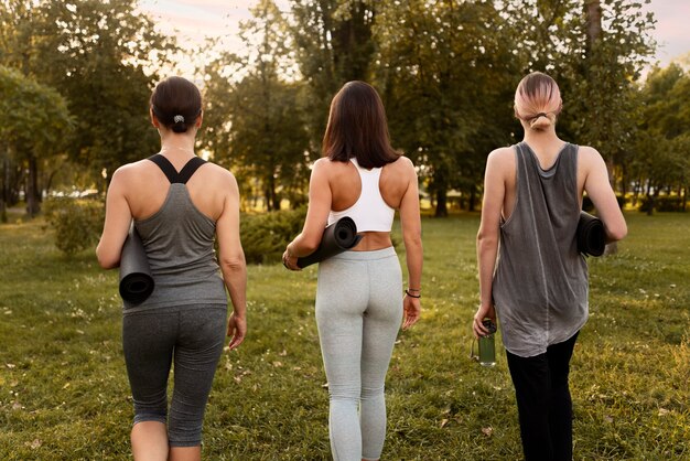 Back view women holding yoga mats