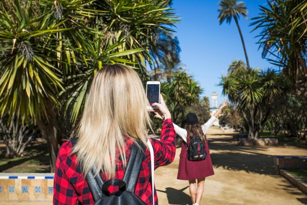 公園で写真を撮っているバックビューの女性