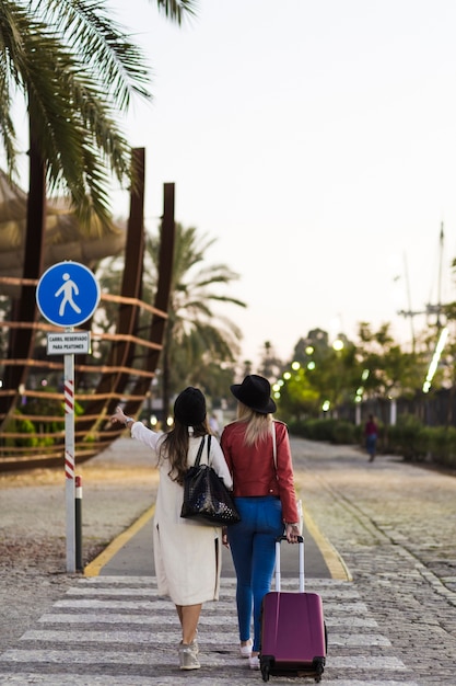 Free photo back view women with suitcase