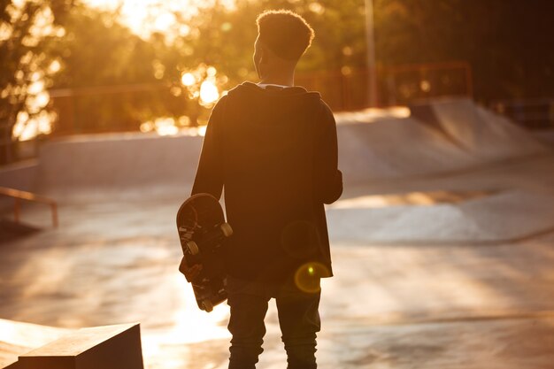 Back view of a young african male teenager with earphones