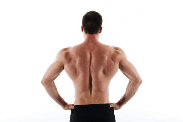 Back view of young athletic sports man standing with hands on his waist