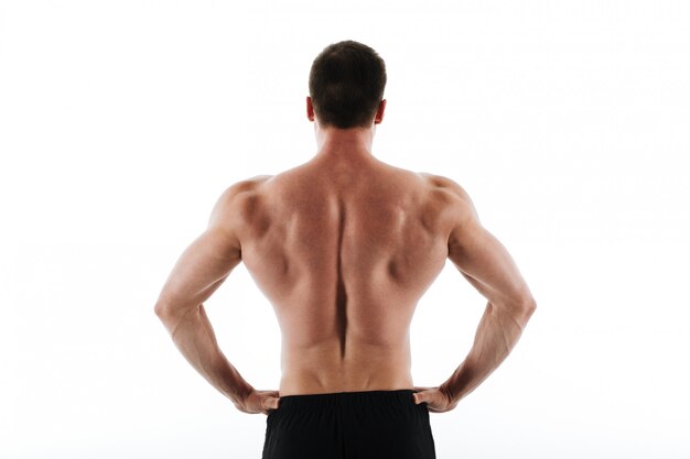 back view of young athletic sports man standing with hands on his waist