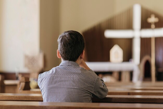 教会で祈っている少年の背面図