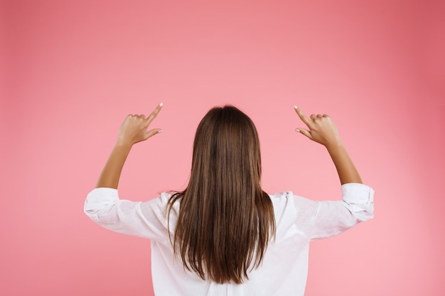 Back view of young chetnut woman in trendy spring outfit