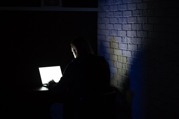 Back view of young concentrated man using laptop