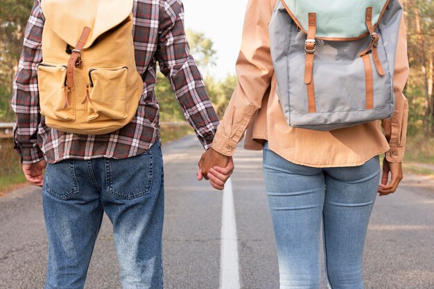 Back view young couple holding hands