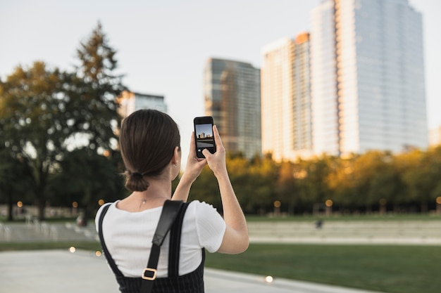 Free photo back view young female taking a picture