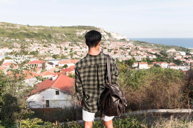 Back view young man enjoying landscape