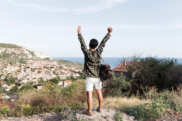 Back view young man enjoying landscape