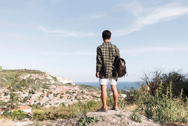 Back view young man enjoying landscape