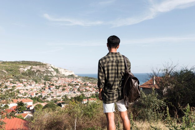 Back view young man enjoying landscape