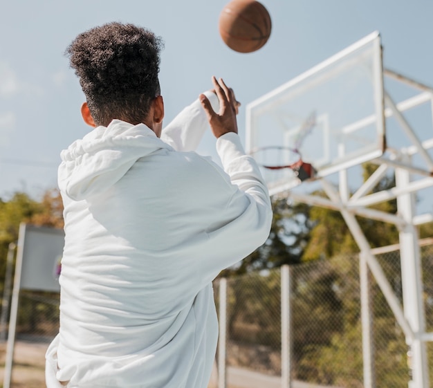 バスケットボールをしている若い男の背面図