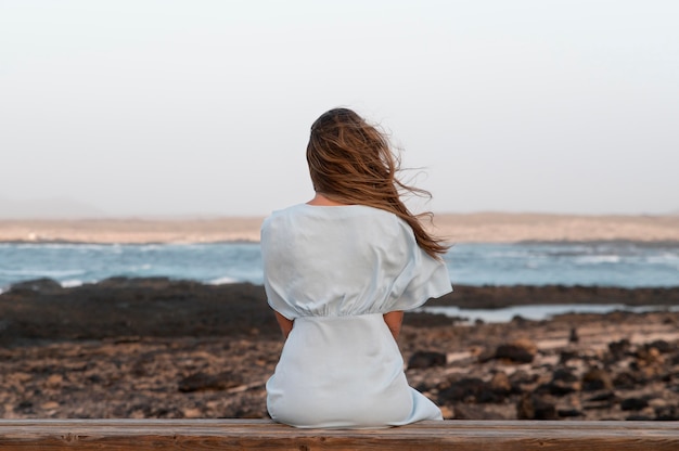 Back view young woman looking at the ocean