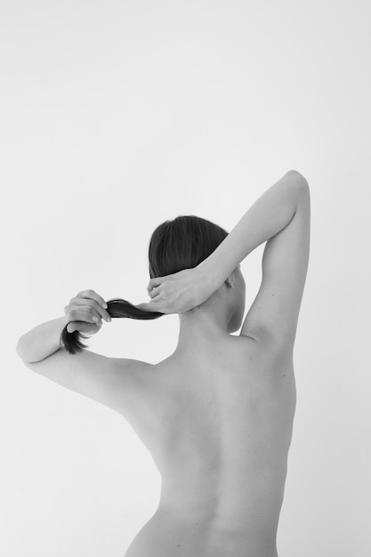 Foto gratuita giovane donna di vista posteriore che posa in bianco e nero