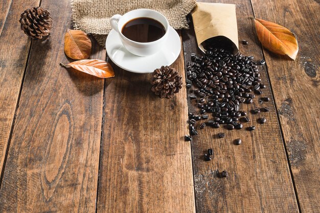 テーブルの上のコーヒーとコーヒー豆のカップ。暗い背景。 プレミアム写真