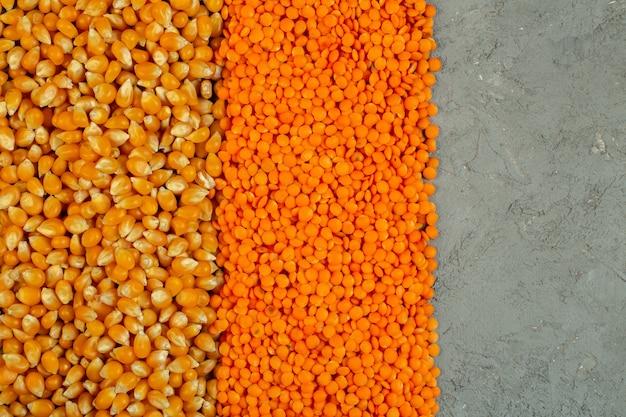 Background of corn seeds and red lentils top view