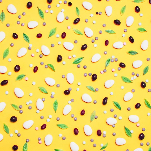 Background decorated with dragees, sprinkles and leaves 