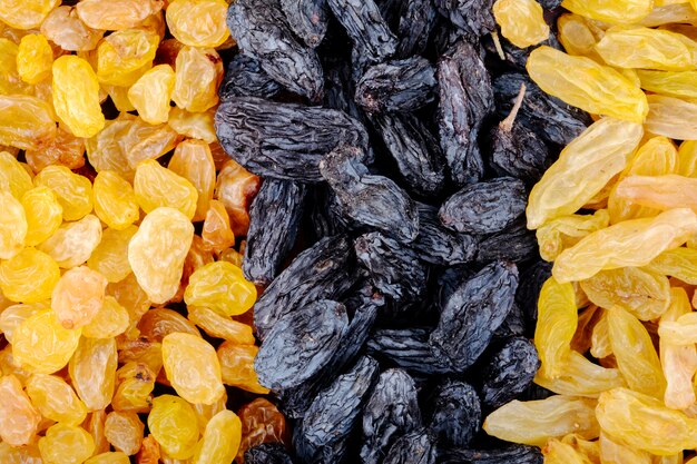 Background of dried fruits black and yellow raisins top view