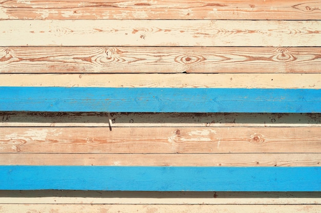 無料写真 明るい模様の古い板の背景明るい太陽の下で古い納屋の壁風化して日焼けした木の板に古い青と白のペンキの残骸が残っています
