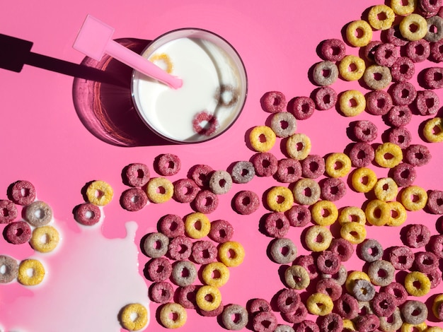 Background full of fruit cereal loops and glass of milk