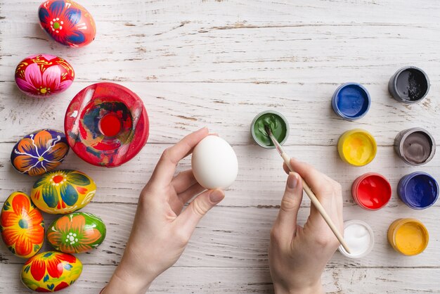 Background of hands with eggs and paint jars