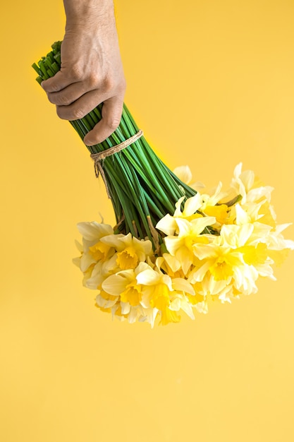 Background male hands with a bouquet of flowers .