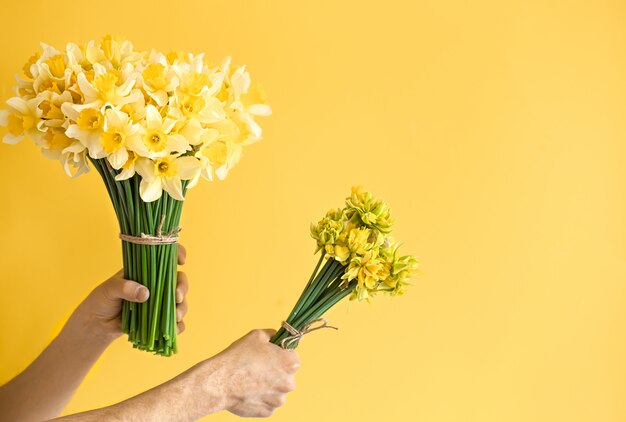 Background male hands with a bouquet of flowers.