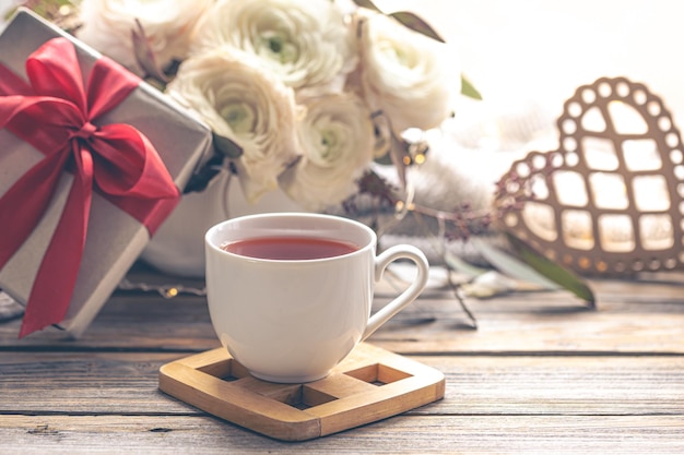 Free photo background for valentines day with a cup of tea and flowers