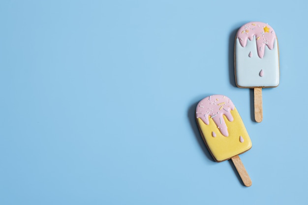 Background with festive gingerbread cookies in the form of ice cream on a stick, covered with glaze copy space.