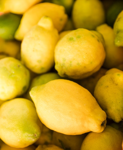 Предпосылка желтого свежего сочного лимона на рынке