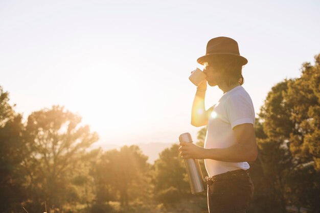 Backlit man drinking in nature