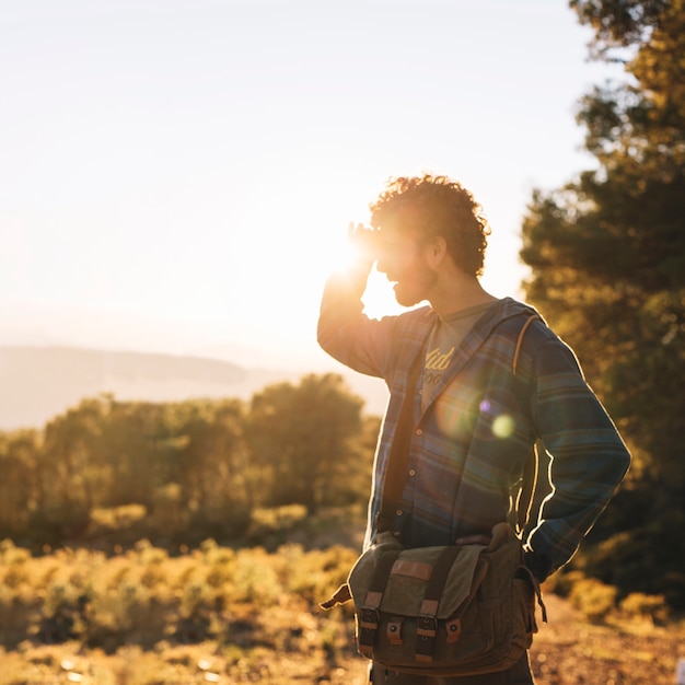 Free photo backlit man using binoculars