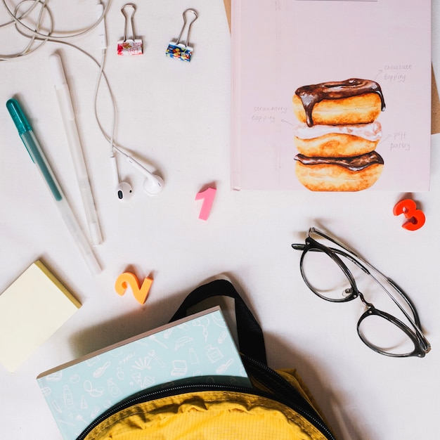 Backpack near glasses and stationery